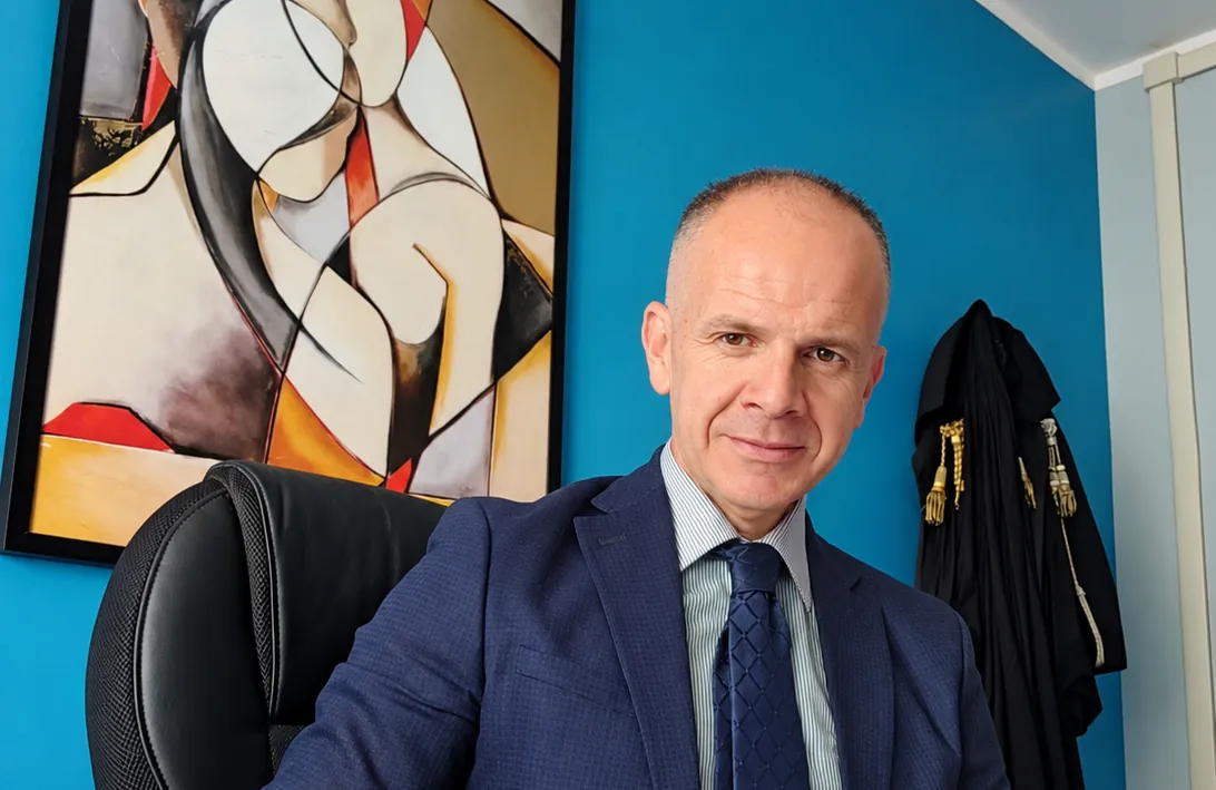 Studio Legale Cuccuru: l'avvocato alla scrivania, con la toga alle spalle