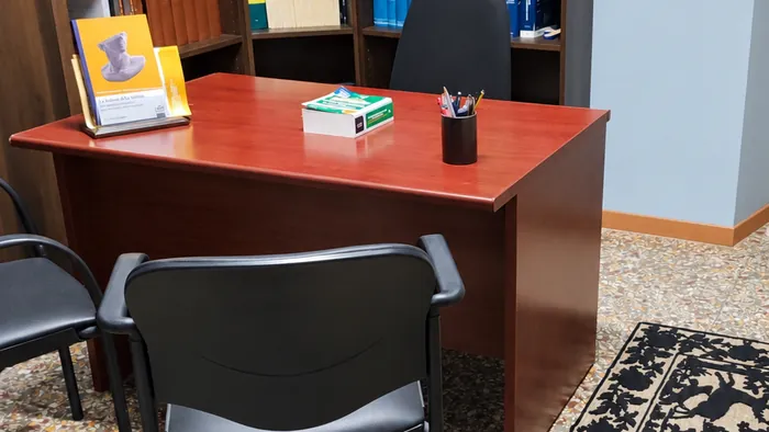 Una stanza dello studio con la scrivania e le sedie per i colloqui