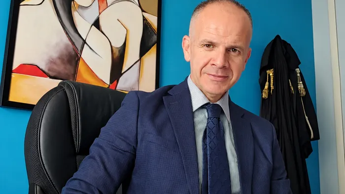 L'avvocato alla scrivania, con la toga appesa alle spalle